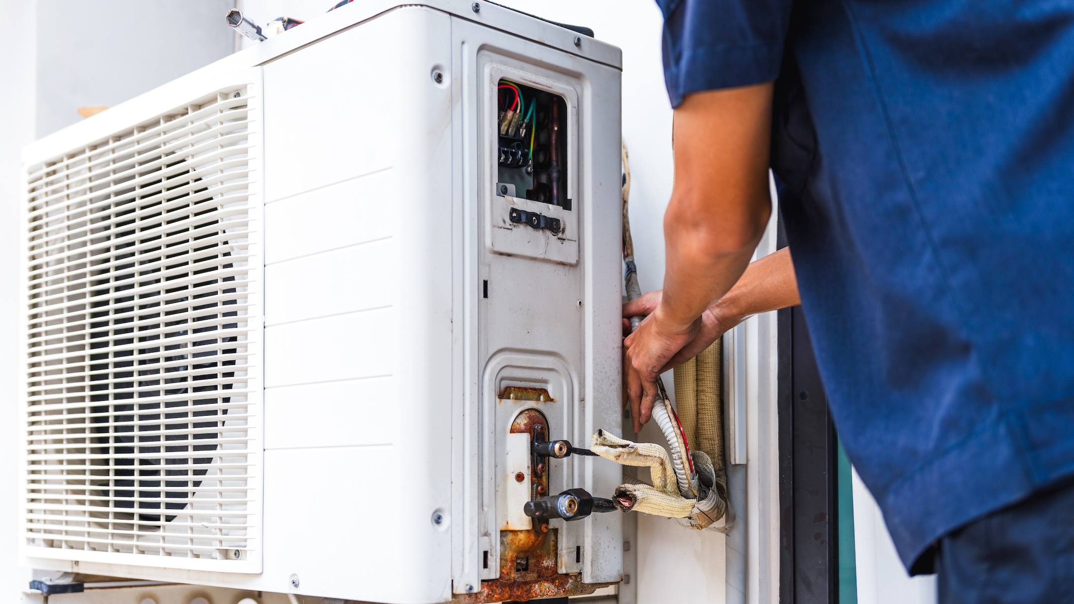 HVAC Technician Fixing an Outdoor Air Conditioning Unit, Professional Repairman Working on an AC System, Hands of an Electrician Repairing an HVAC Unit
