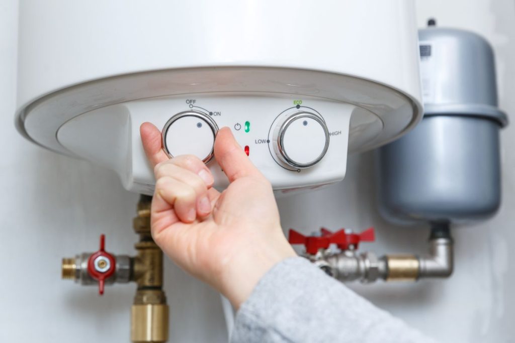 hand-turning-on-electric-water-heater-boiler (1)